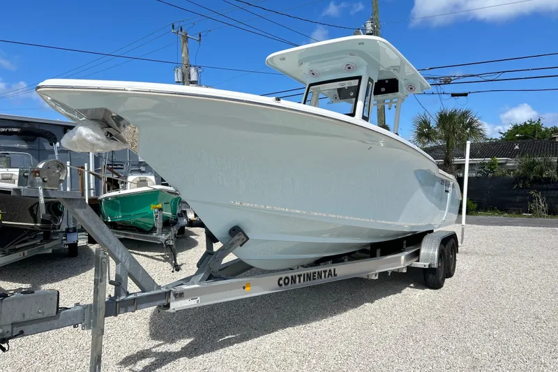 The Image of 2026 Key West 260 Center Console boat on trailer, parked outdoors under blue sky. - 0