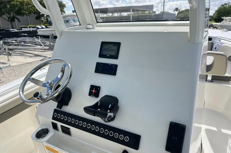 Slide: The Image of 2026 Key West 260 Center Console boat dashboard with steering wheel and controls. - 33
