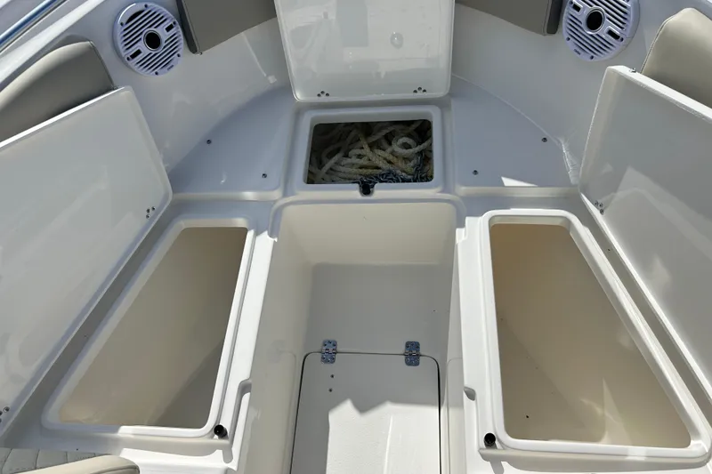 Slide: The Image of 2026 Key West 260 Center Console boat storage compartments with open hatches and visible rope. - 36