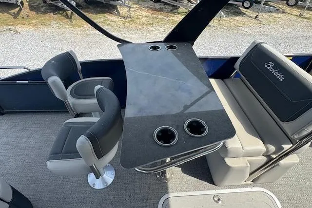 Slide: The Image of 2026 Barletta Cabrio 24UE boat interior with seating and table featuring cup holders. - 13