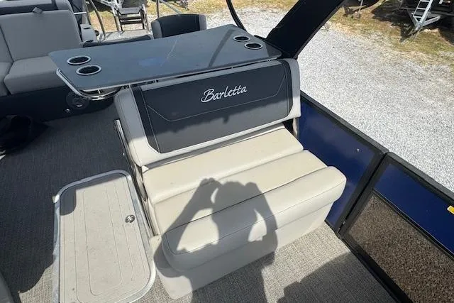 Slide: The Image of 2026 Barletta Cabrio 24UE boat interior with seating and table, featuring cup holders. - 14