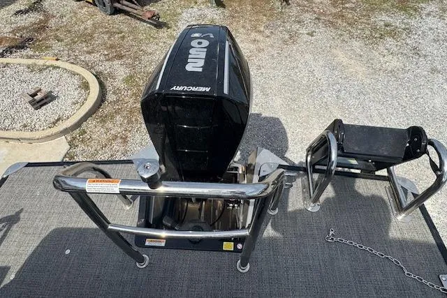 Slide: The Image of 2026 Barletta Cabrio 24UE boat with Mercury outboard motor, rear view on gravel surface. - 20