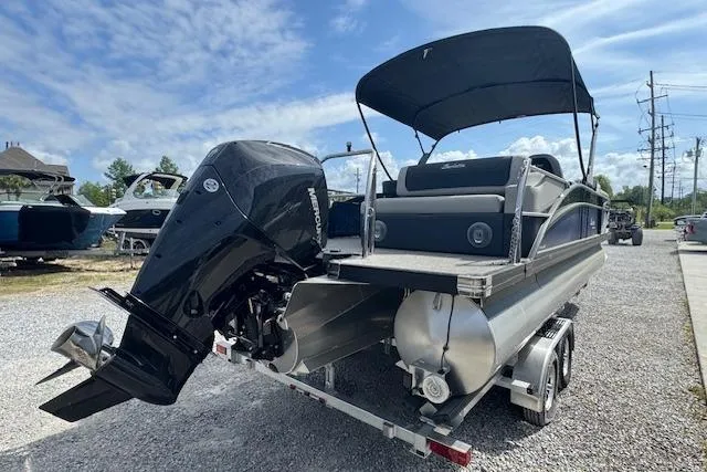 Slide: The Image of 2026 Barletta Cabrio 24UE pontoon boat with outboard motor and canopy, parked on a trailer. - 4