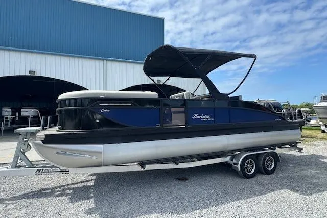 Slide: The Image of 2026 Barletta Cabrio 24UE pontoon boat on trailer, parked outdoors. - 7