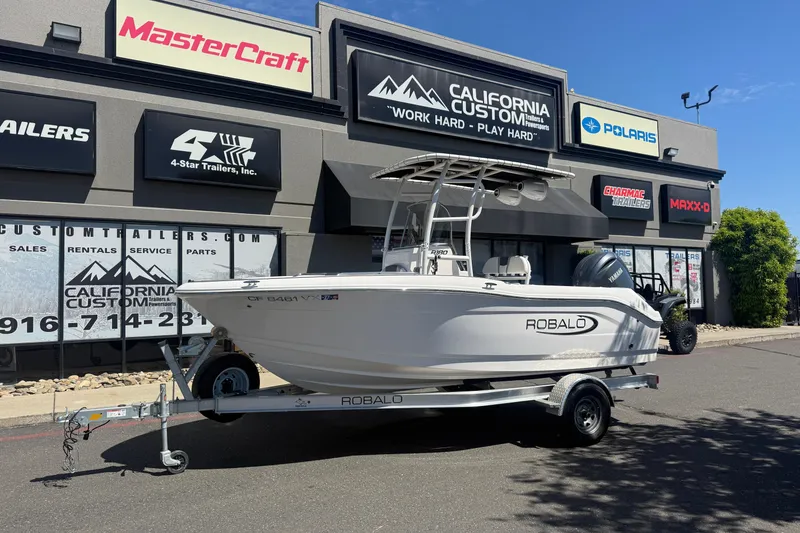 The Image of 2025 Robalo R180 Center Console boat on trailer outside dealership. - 0