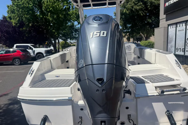 Slide: The Image of 2025 Robalo R180 Center Console boat with a 150 horsepower engine, parked outdoors. - 12