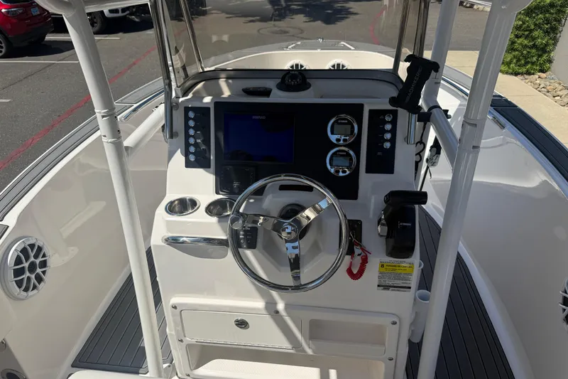 Slide: The Image of 2025 Robalo R180 Center Console boat dashboard with steering wheel and navigation controls. - 14