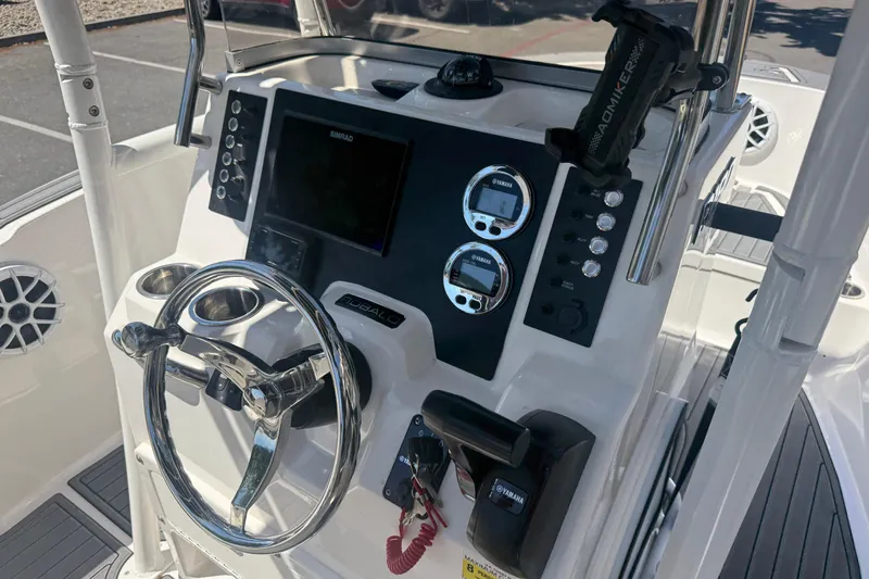Slide: The Image of 2025 Robalo R180 Center Console boat dashboard with steering wheel and electronic controls. - 15