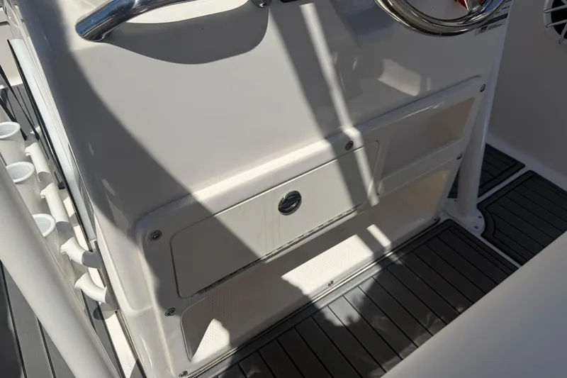 Slide: The Image of 2025 Robalo R180 Center Console helm with storage compartments and rod holders. - 17