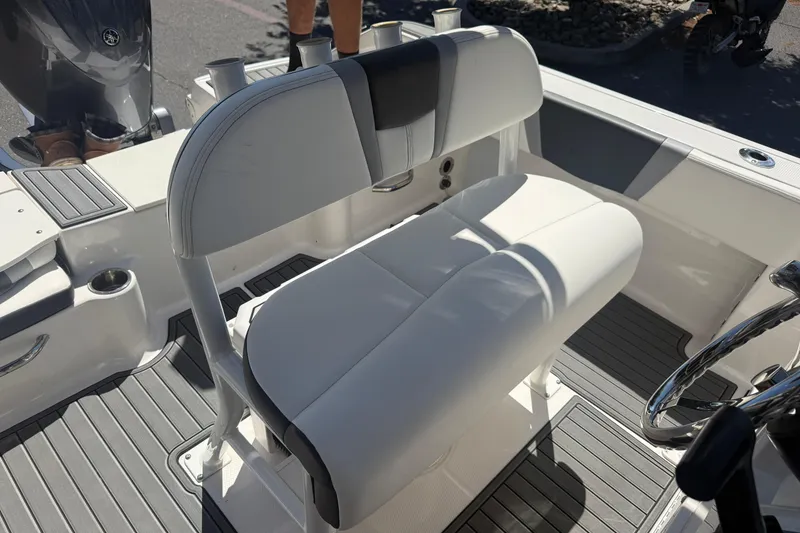 Slide: The Image of 2025 Robalo R180 Center Console boat interior with cushioned seating and steering wheel. - 19