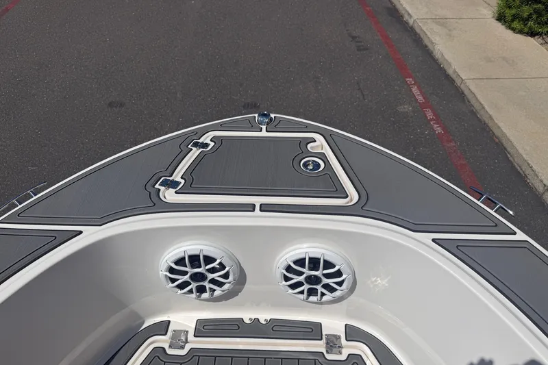 Slide: The Image of 2025 Robalo R180 Center Console boat deck with speakers and storage hatch. - 24