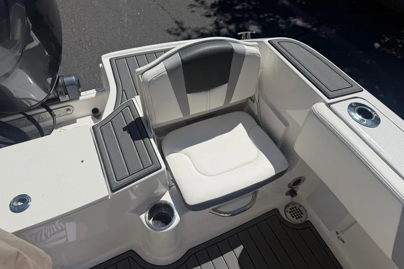 Slide: The Image of 2025 Robalo R180 Center Console boat seating area with cushioned seat and cup holder. - 30