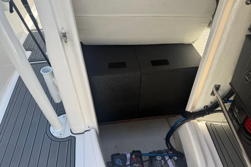 Slide: The Image of 2025 Robalo R180 Center Console interior storage compartment with black boxes and wiring. - 32