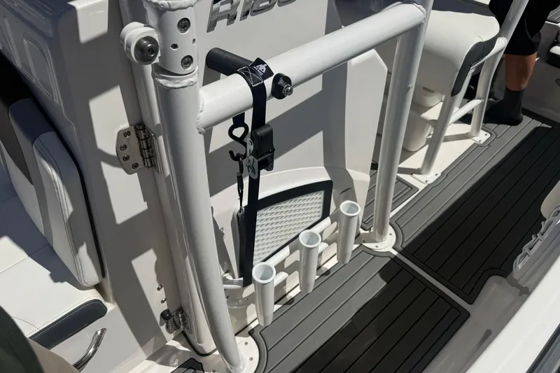 Slide: The Image of 2025 Robalo R180 Center Console boat interior with rod holders and seating. - 33