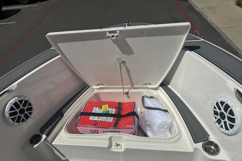 Slide: The Image of Open storage compartment on 2025 Robalo R180 Center Console boat with life jackets. - 38