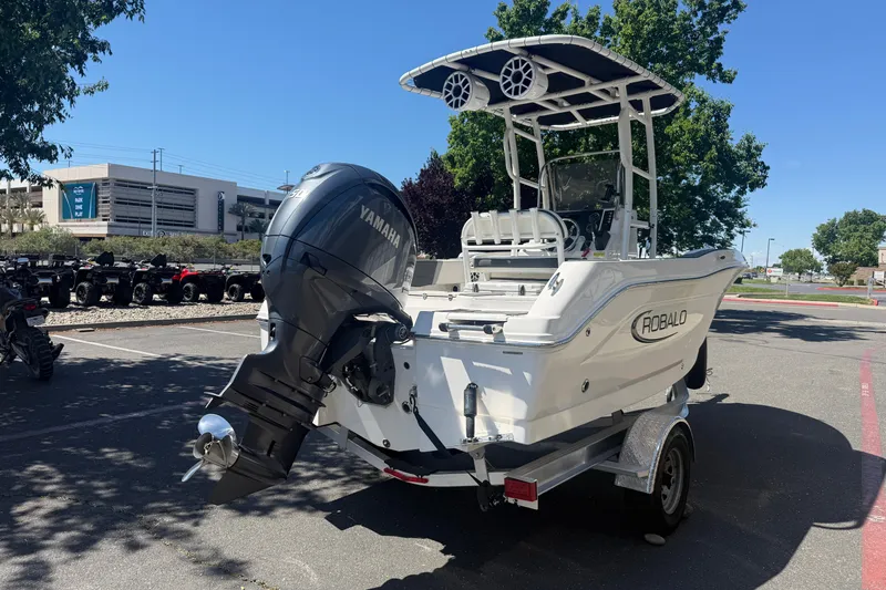 Slide: The Image of 2025 Robalo R180 Center Console boat with Yamaha outboard engine in a parking lot. - 4