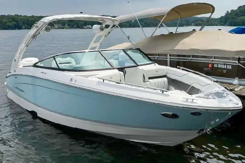 The Image of 2025 Regal LX4 boat docked on a serene lake, showcasing sleek design and luxury features. - 0