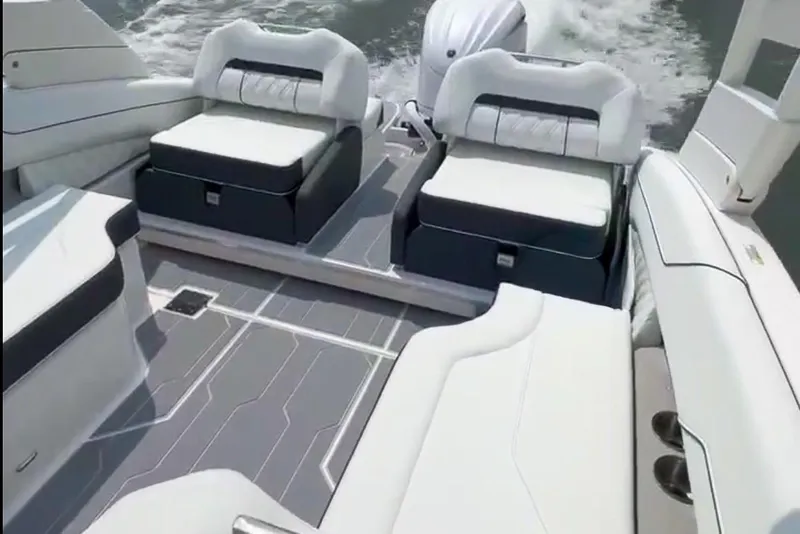 Slide: The Image of 2025 Regal LX4 boat on trailer, parked outdoors, surrounded by trees and other boats. - 7