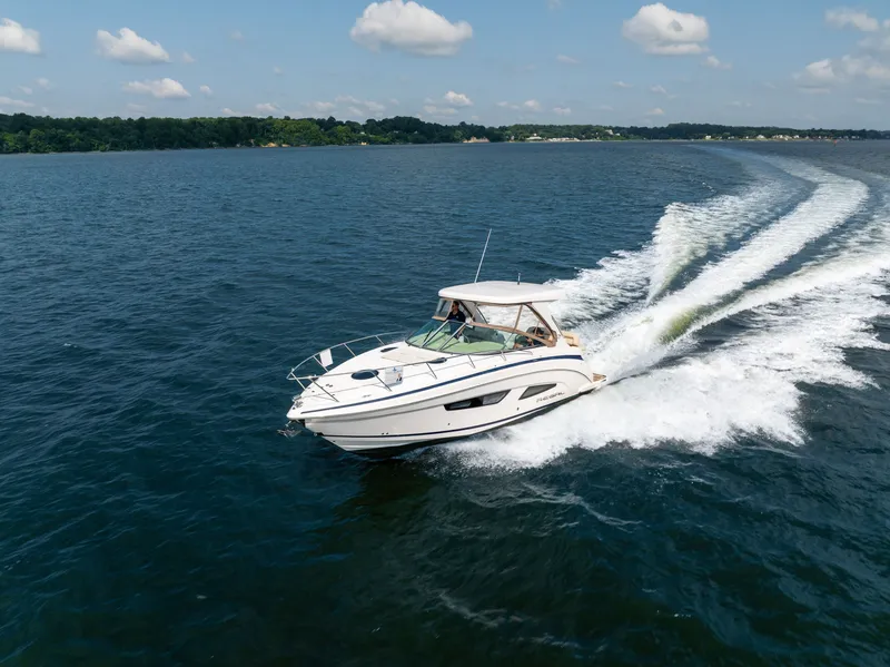 Slide: The Image of A 2019 Regal 33 Express boat speeds across the water under a blue sky. - 10