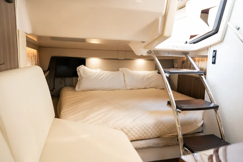 Slide: The Image of Interior of a 2019 Regal 33 Express with a cozy bed and ladder. - 23