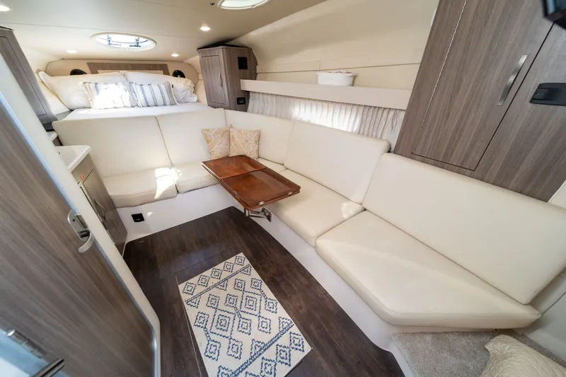 Slide: The Image of Interior of the 2019 Regal 33 Express with elegant seating area and wooden table. - 32
