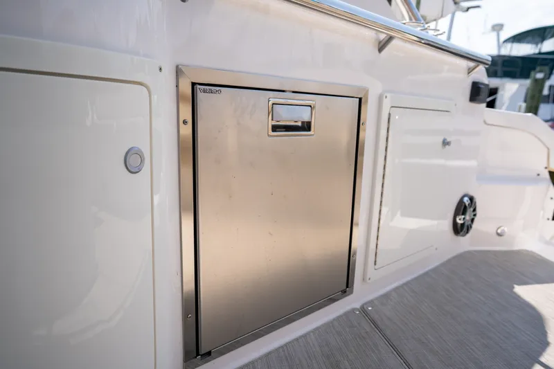 Slide: The Image of The 2019 Regal 33 Express features a stainless steel refrigerator door in the cockpit area. - 19