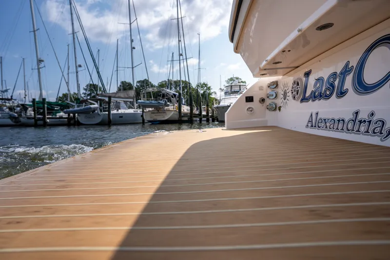 Slide: The Image of The image shows the stern of a 2019 Regal 33 Express boat with a wooden deck. - 15