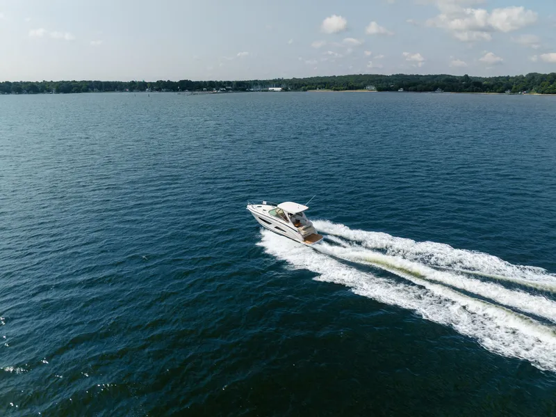 Slide: The Image of A 2019 Regal 33 Express boat speeds across a calm lake. - 8