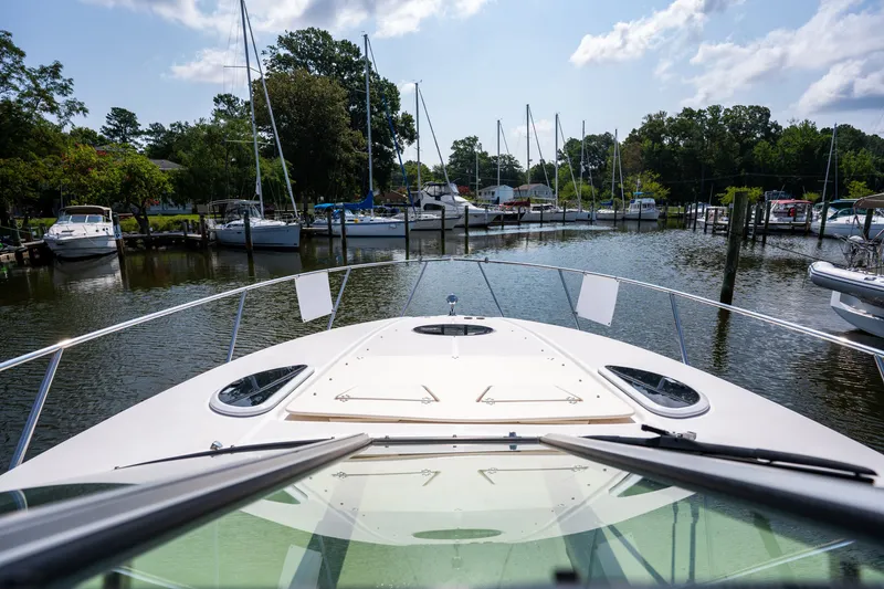 Slide: The Image of View from the bow of a Regal 33 Express overlooking a calm marina with several sailboats. - 17