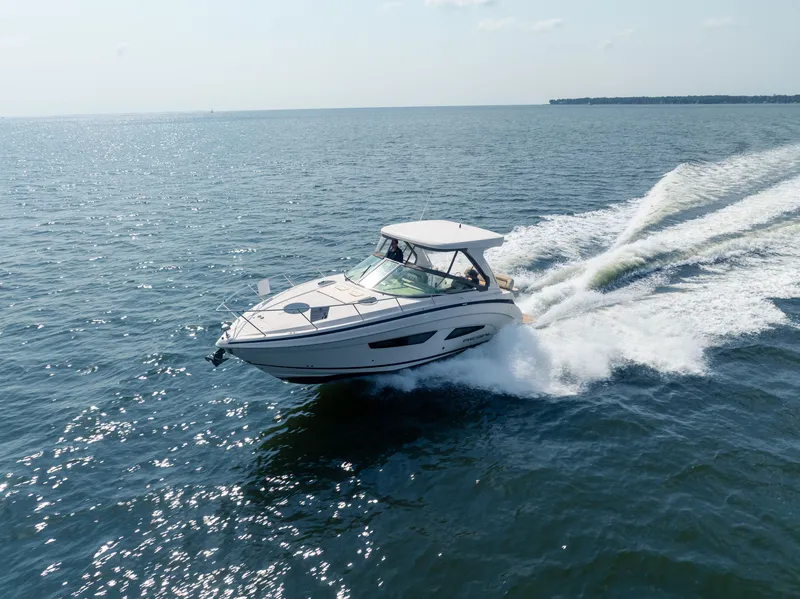 The Image of A 2019 Regal 33 Express speeds across the water, surrounded by a vast seascape. - 0