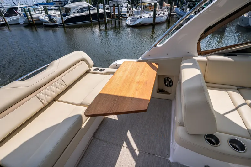 Slide: The Image of Interior of a 2019 Regal 33 Express with beige leather seating and a wooden table. - 14