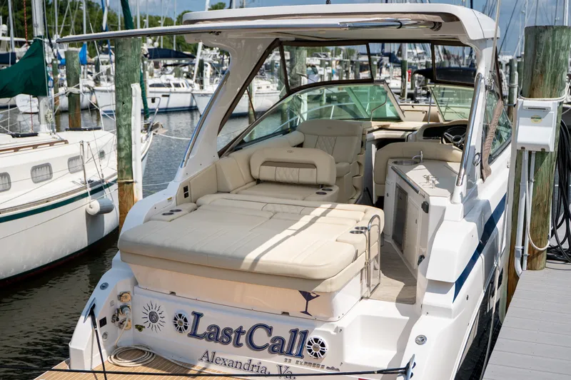 Slide: The Image of The image shows a 2019 Regal 33 Express docked among other boats. The cockpit features beige seating and a helm. - 47