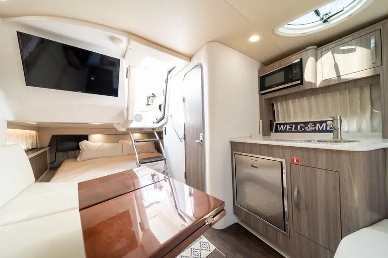 Slide: The Image of Interior of the 2019 Regal 33 Express with kitchen, bed, and TV. - 36
