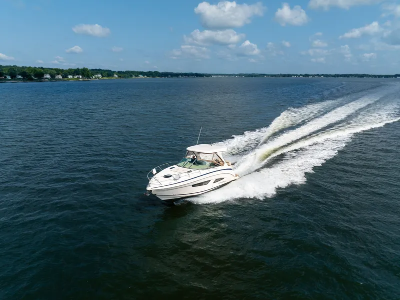 Slide: The Image of A 2019 Regal 33 Express speeds across the water under a blue sky. - 5