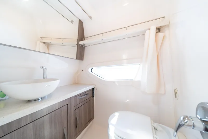 Slide: The Image of The image shows a modern boat bathroom with a sink, toilet, and mirror. - 38
