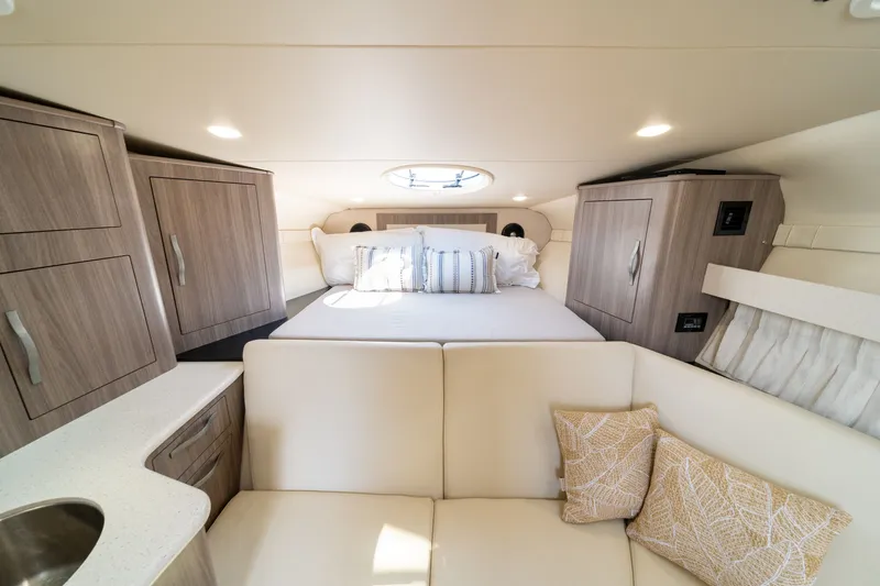 Slide: The Image of 2019 Regal 33 Express: Elegant interior with a double bed, wood cabinetry, and beige sofa. - 34