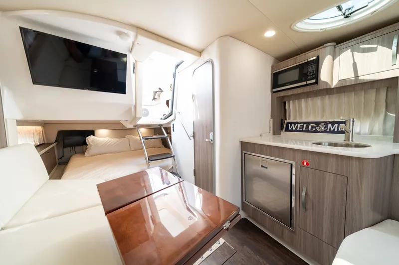Slide: The Image of Interior of a 2019 Regal 33 Express with kitchen, sleeping area, and dining table. - 35