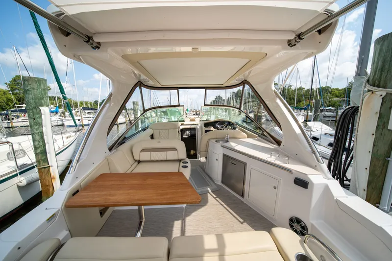 Slide: The Image of The image shows the cockpit of a 2019 Regal 33 Express with beige seating and a wooden table. - 42