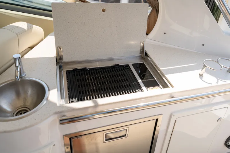 Slide: The Image of The 2019 Regal 33 Express features an outdoor kitchen with a grill, sink, and storage. - 31
