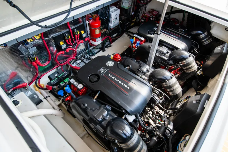 Slide: The Image of Engine room of a 2019 Regal 33 Express with twin Volvo Penta engines and a red fire extinguisher. - 48