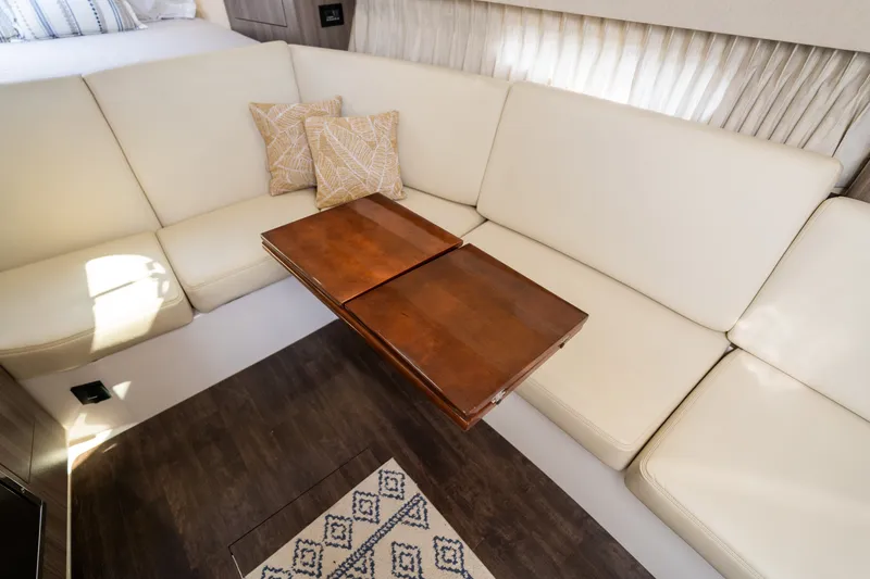 Slide: The Image of Interior of the 2019 Regal 33 Express with beige sofa and wooden table. - 21