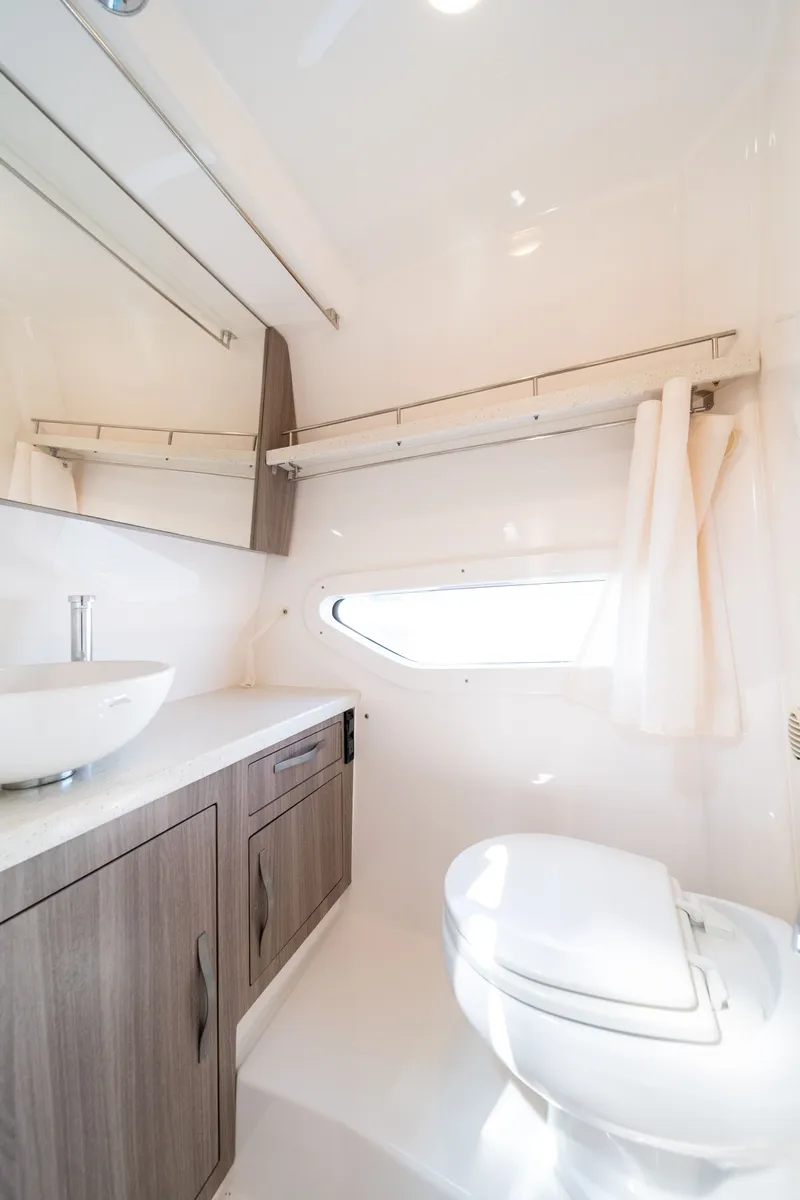 Slide: The Image of The image shows a modern boat bathroom with a sink, toilet, and window. - 37