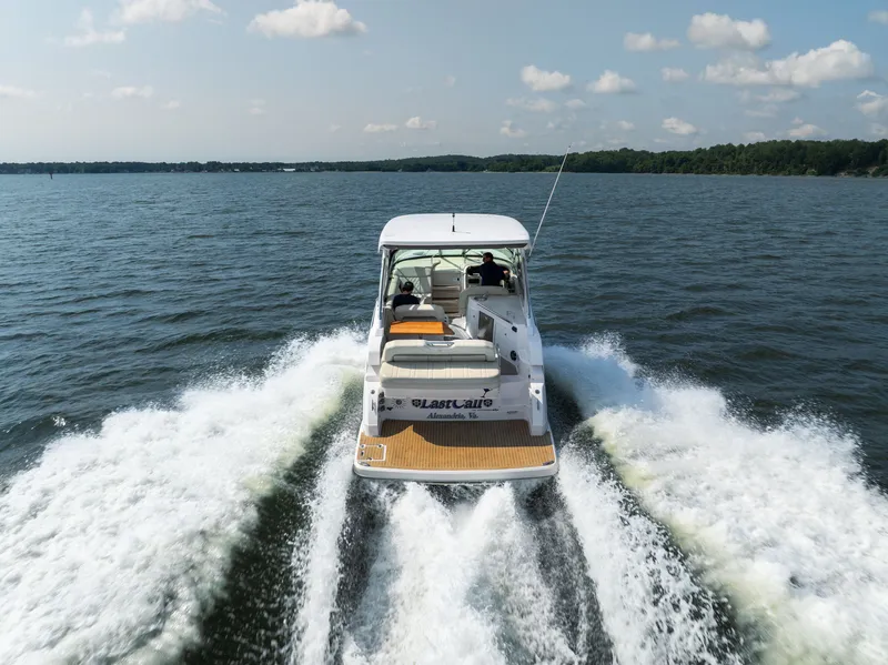 Slide: The Image of A 2019 Regal 33 Express speeds across the water, showing a clear view of the stern. - 7