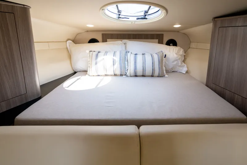 Slide: The Image of Cabin of the 2019 Regal 33 Express with a cozy bed and skylights. - 27