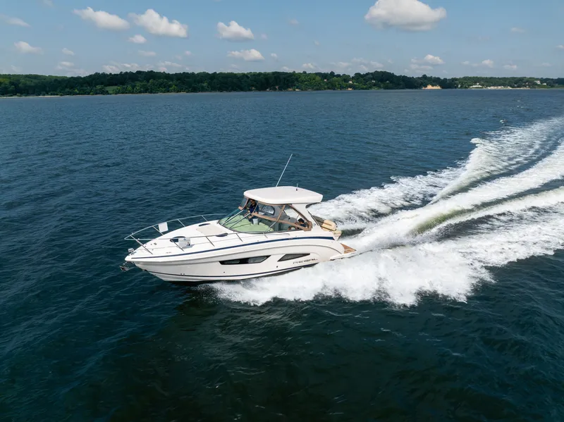 Slide: The Image of A 2019 Regal 33 Express speeds across the water under a clear sky. - 9