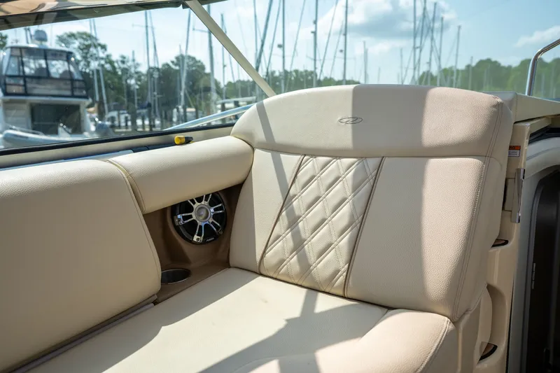 Slide: The Image of The image shows the seating area of a 2019 Regal 33 Express with beige upholstery and a speaker. - 12