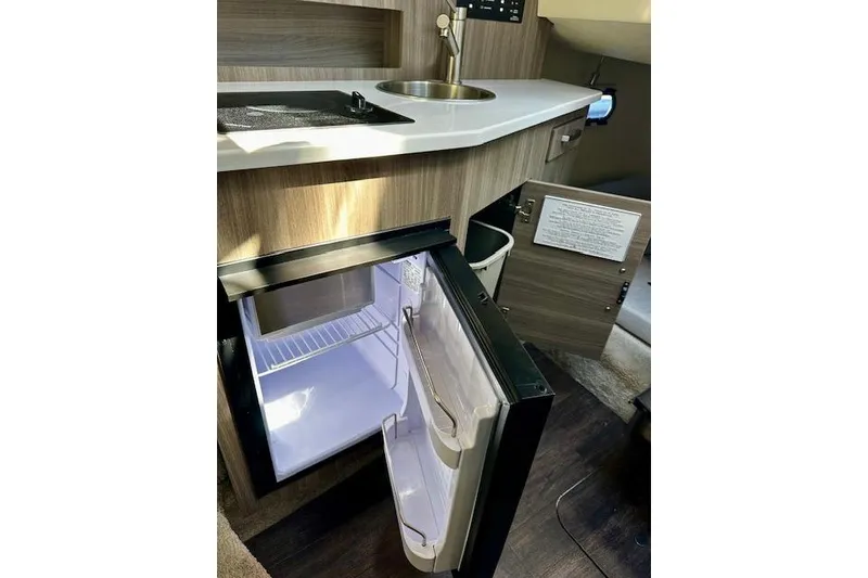 Slide: The Image of Compact kitchen area in 2022 Regal 26 XO boat with open fridge and sink. - 13