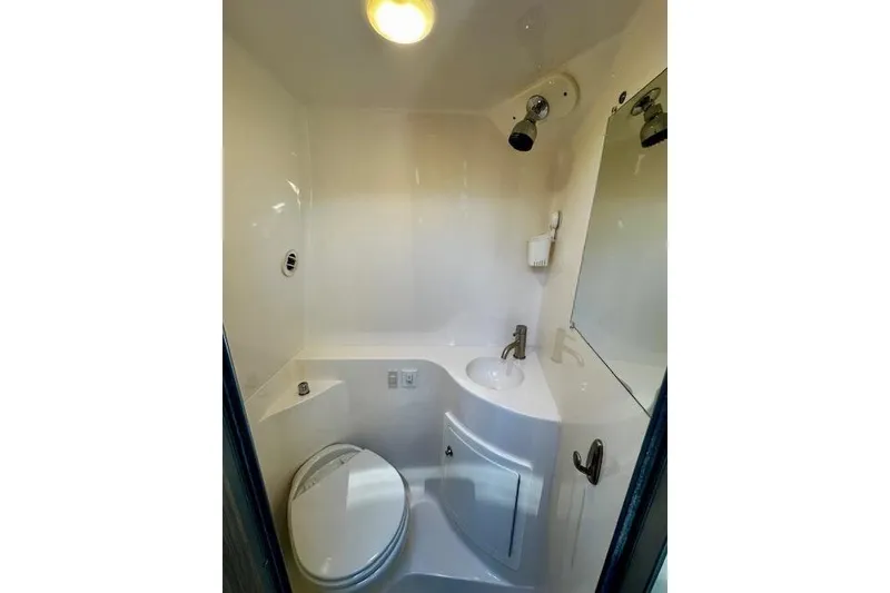 Slide: The Image of Compact bathroom in 2022 Regal 26 XO boat with toilet, sink, and mirror. - 14