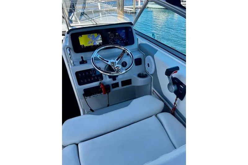 Slide: The Image of Cockpit of 2022 Regal 26 XO boat with steering wheel and navigation display. - 16
