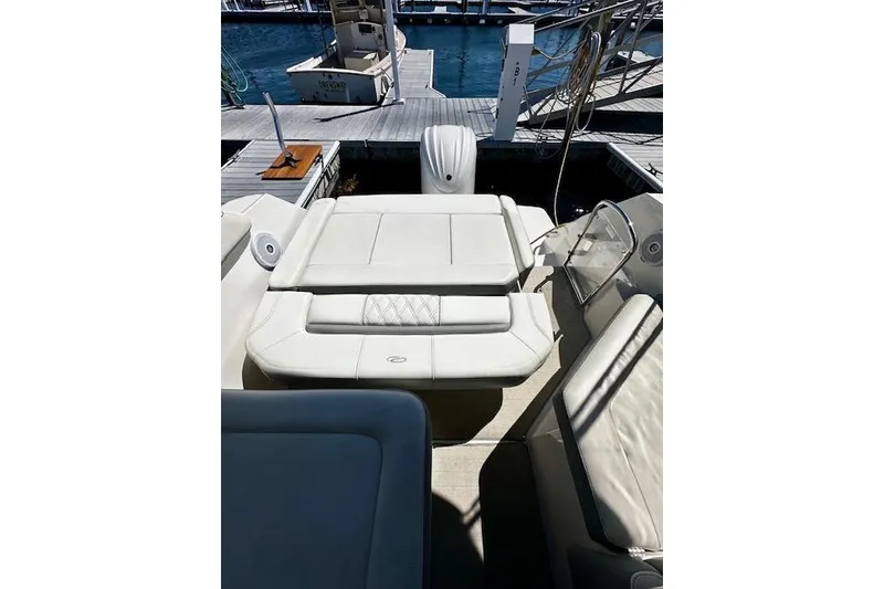 Slide: The Image of 2022 Regal 26 XO boat interior with white seating at a marina dock. - 21